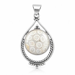May include: A silver pendant featuring a circular fossil coral cabochon with a white and tan starburst pattern. The stone is encased in a polished silver frame with a twisted rope texture, accented by small silver beads at the top and bottom.