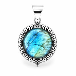 May include: A round pendant featuring a polished labradorite gemstone with blue and green iridescence. The stone is set in a silver frame decorated with a beaded border and a small triangular cluster of silver spheres at the bottom and top.