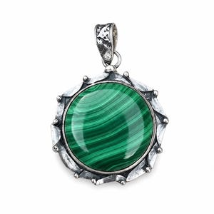 May include: A round pendant featuring a polished green malachite stone with dark banded patterns, set within a textured, oxidized silver frame that has a jagged, petal-like edge and a sturdy, patterned bail at the top for a necklace chain.