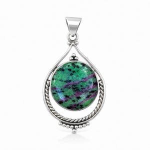 May include: A circular pendant featuring a polished green and magenta zoisite stone with black inclusions, set within a silver frame. The frame has a twisted rope design on the lower half, a smooth bail at the top, and small silver bead accents.
