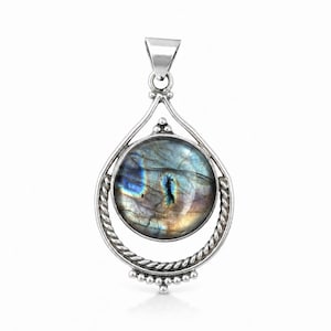 May include: A sterling silver pendant featuring a round, polished labradorite gemstone with iridescent blue and gold flashes. The stone is encased in a teardrop-shaped frame with twisted rope detailing and small silver bead accents at the base.