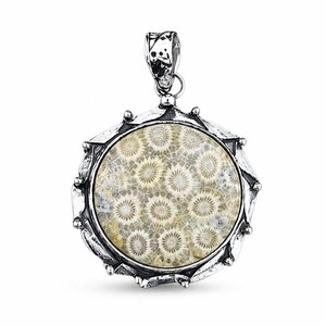 May include: A circular pendant featuring a fossilized coral stone with a beige and white starburst pattern, encased in a textured, oxidized silver setting with a decorative scalloped edge and a sturdy bail at the top for hanging on a chain.