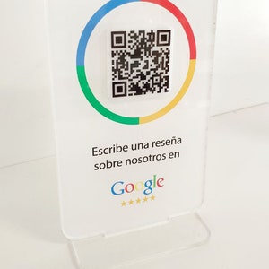 Può includere: Un cartello bianco con un codice QR al centro circondato da un cerchio rosso, giallo, verde e blu. Il cartello dice "Ayúdanos a crecer" e "Escribe una reseña sobre nosotros en Google" con cinque stelle dorate sotto il logo di Google.