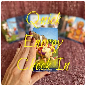 May include: A hand holding a tarot card with the Empress card face up. The card is blue with a green and yellow landscape. The text "Quick Energy Check In" is written in yellow on the image.