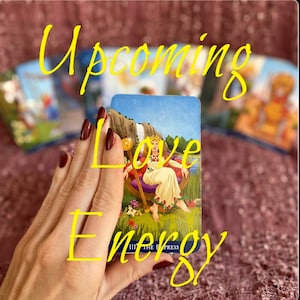 Peut inclure: Une lecture de cartes de tarot avec la carte de l'Impératrice visible, avec le texte "Upcoming Love Energy" écrit en jaune sur la carte.