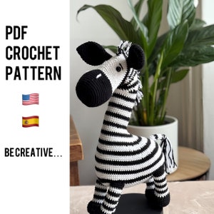 May include: A crochet zebra pattern in black and white stripes. The pattern is available in English and Spanish. The text "PDF CROCHET PATTERN" is displayed above the zebra. The text "BE CREATIVE..." is displayed below the zebra.