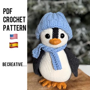 May include: Crochet pattern for a penguin wearing a blue hat and scarf. The pattern is available in English and Spanish.