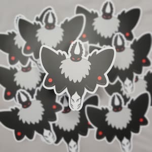 May include: A collection of black and white moth stickers with red accents. The moths have fuzzy bodies and large wings.