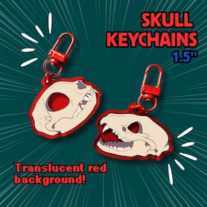 May include: Two skull keychains with translucent red backgrounds. The keychains are 1.5 inches in size and feature a red clasp. The text on the image reads "SKULL KEYCHAINS" and "Translucent red background!"