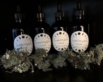 May include: Four dark glass bottles with dropper tops and white labels. The labels have a moon and stars design and the text "creativ Impulses usnea Exp. 10/23, 25 ml".