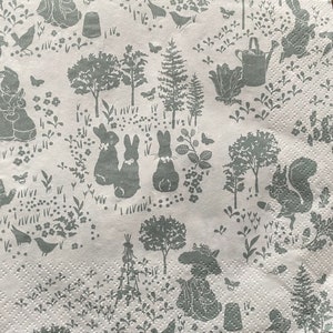 May include: A white background with a repeating pattern of grey rabbits, trees, and other woodland creatures. The pattern is reminiscent of a vintage wallpaper or fabric design.