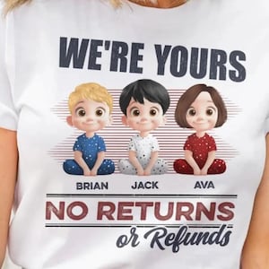 Puede incluir: Camiseta blanca con un gráfico de tres niños de dibujos animados sentados. El texto "We're Yours No Returns or Refunds" está impreso en la camiseta.