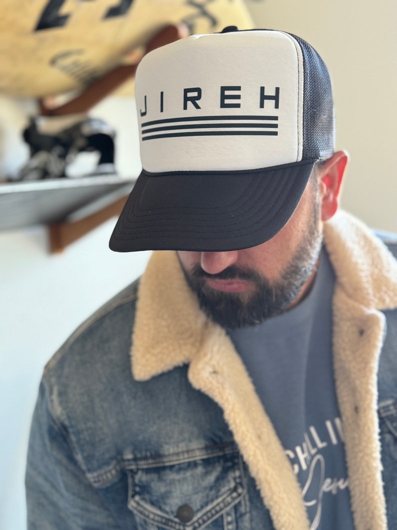 May include: A black and white trucker hat with the word "JIREH" printed in black on the front. The hat has a black mesh back and a white front panel.
