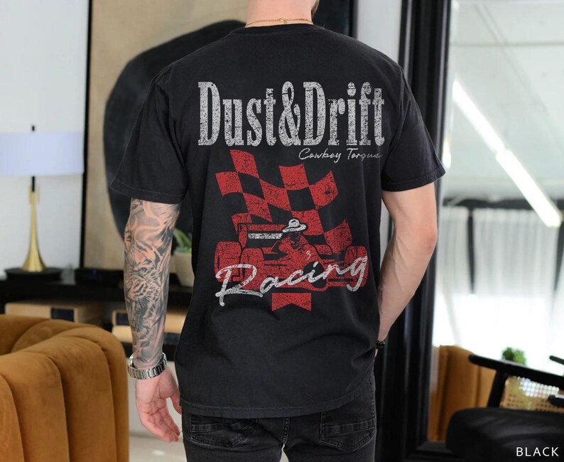 May include: Black t-shirt with a distressed graphic featuring the words "Dust & Drift" above a red and black checkered flag and a race car. The shirt also has the words "Cowboy Torque" and "Racing".