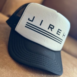 May include: A black and white trucker hat with the word "JIREH" printed in black on the front. The hat has a black mesh back and a white front.