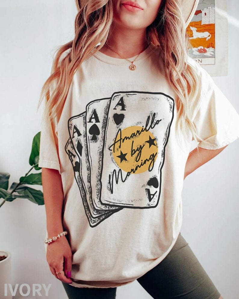 May include: A white t-shirt with a graphic of playing cards and the text "Amarillo by Morning".