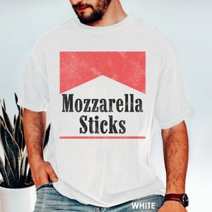 May include: White t-shirt with a red and white graphic that says "Mozzarella Sticks" in black text.