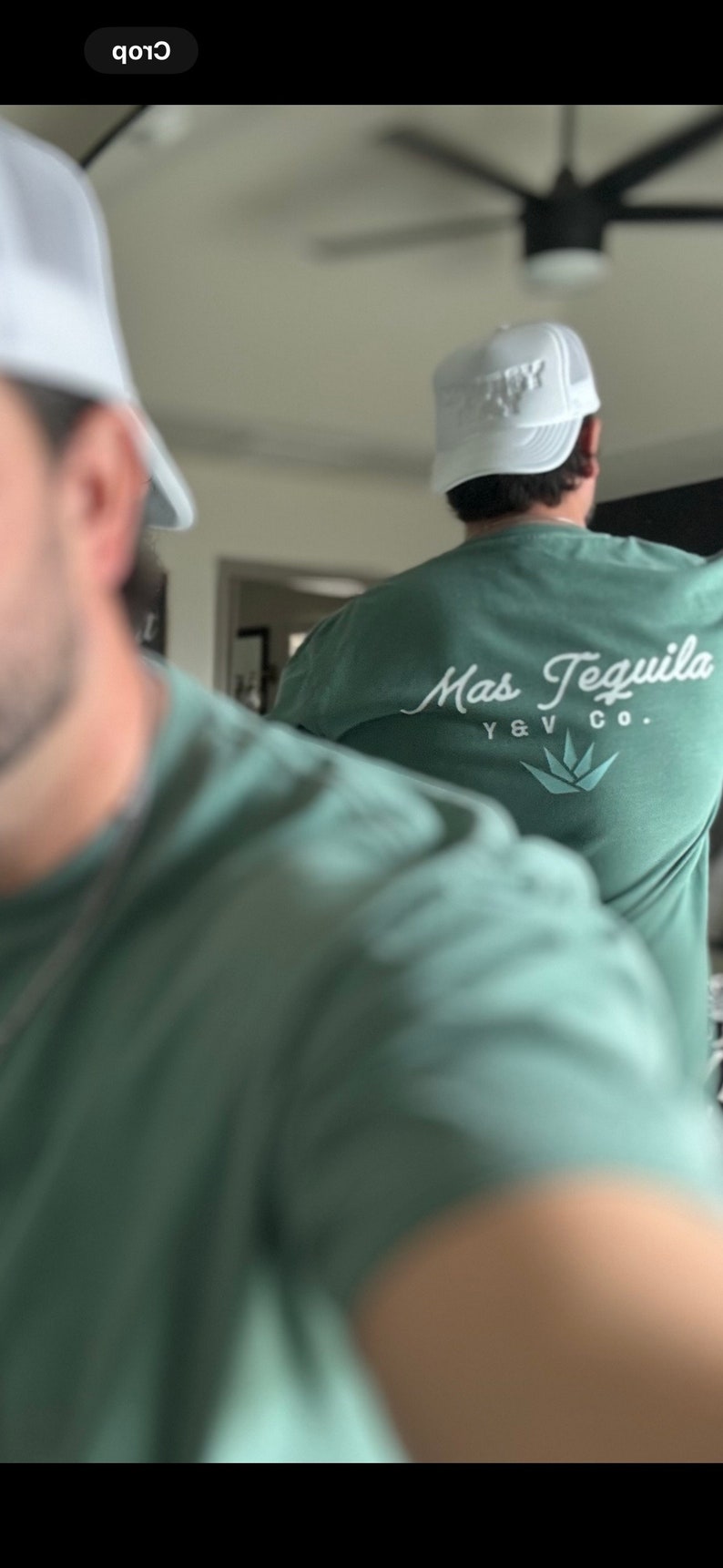 May include: Two people wearing green t-shirts with white hats. The person at the back has a white t-shirt with the text "Mas Tequila Y & V Co." printed on the back.