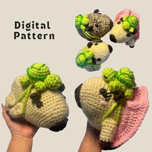May include: A collection of crocheted pug dog plush toys, each with green brussels sprouts on their heads. The dogs are beige with brown accents and black button eyes. The text "Digital Pattern" is visible.