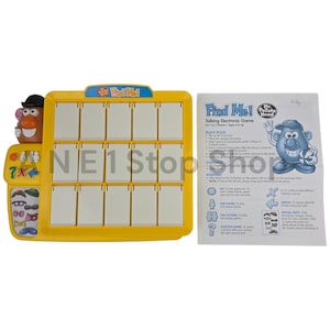 Pode incluir: Um jogo eletrônico amarelo "Find Me!" com o personagem Mr. Potato Head. O jogo tem uma grade de quadrados em branco, um painel de controle com botões e uma folha de instruções. Projetado para 1 ou 2 jogadores.