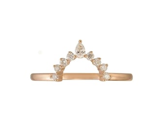 May include: A rose gold ring with a curved design, set with multiple small, clear gemstones. The ring's band is a thin, continuous loop, and the gemstones are arranged in an arch shape, with a larger pear-shaped stone at the top.