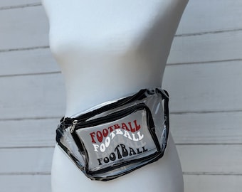 May include: Clear plastic fanny pack with a black zipper and adjustable strap. The pack has a red, white, and black design that says "FOOTBALL" three times.