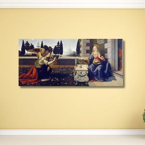 May include: A rectangular canvas print of a Renaissance painting showing an angel kneeling before a woman. The angel wears a gold wing and red and green garments. The woman is seated, wearing a blue robe. A small table is between them.