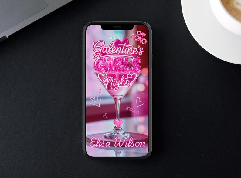 Op de afbeelding: Een smartphone toont een roze afbeelding voor Galentine's Girls Night. Het ontwerp toont een martiniglas met de tekst "Galentine's Girls Night" in roze glitter, harten en de naam "Elisa Wilson".