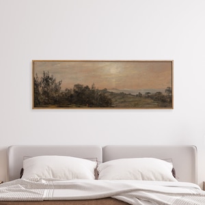 May include: A framed landscape painting depicting a rural scene with trees, hills, and a body of water in the distance. The sky is a soft pink and orange, suggesting a sunset or sunrise.