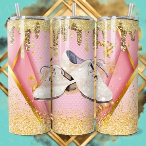 May include: A pink and gold tumbler with a glitter finish. The tumbler features a design of white tap shoes with gold accents. The design has a dripping gold glitter effect.