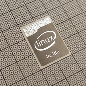 Puede incluir: Una tarjeta gris con el texto "linux inside" y un logotipo "linux" estilizado en blanco. La tarjeta está sobre un fondo de cuadrícula. La parte superior de la tarjeta tiene una sección blanca con texto pequeño.