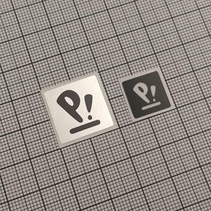 May include: Two square stickers with a black and white design. The design features a stylized "P" with an exclamation point above a horizontal line. One sticker is silver with a black design, and the other is black with a white design.