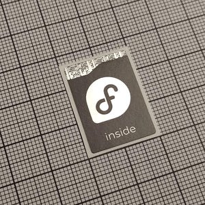 May include: A rectangular sticker with a black background and a white logo, featuring a stylized "f" inside a white oval. The word "inside" is printed in white below the logo. The sticker is on a gray grid.