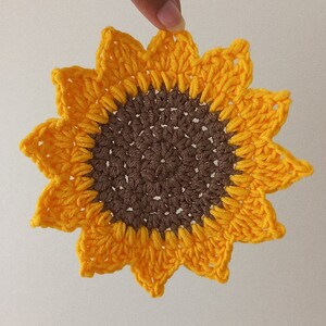 Holding up the sunflower drink coaster