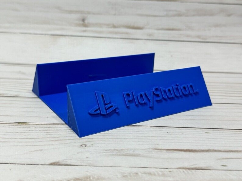 May include: A blue plastic stand with the PlayStation logo and the word "PlayStation" embossed on it.