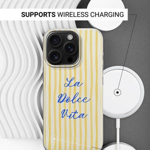 May include: A phone case with a yellow and white striped pattern and the words "La Dolce Vita" in blue script. The case is shown with a wireless charger. The text "Supports Wireless Charging" and "Sides are not printed" are also visible.