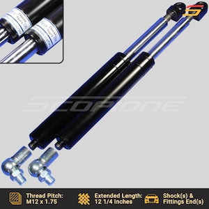 May include: Two black and silver gas struts with a threaded end and ball joint fitting. The struts are 12 1/4 inches long and have a thread pitch of M12 x 1.75.