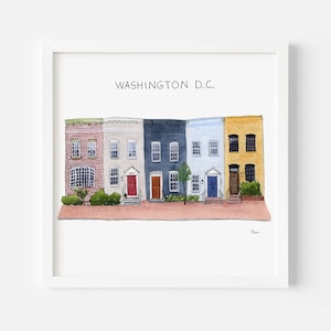 May include: Watercolor print of colorful row houses in Washington D.C. The houses are painted in shades of red, white, navy, light blue, and yellow. The text "WASHINGTON D.C." is printed at the top of the image. The print is framed in a white square frame.