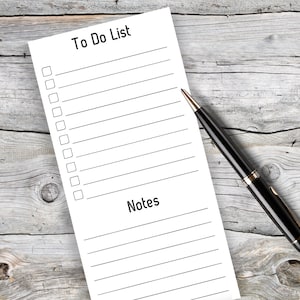 May include: A white to-do list with a black pen on a wooden surface. The list has spaces for 15 items and a section for notes.