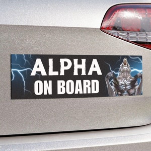 May include: Rectangular car magnet with the text "ALPHA ON BOARD" in white block letters. The magnet features a graphic of a silver wolf with lightning bolts in the background. The magnet is affixed to the rear of a silver car.
