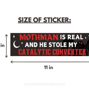 May include: A rectangular black bumper sticker featuring the red text MOTHMAN IS REAL AND HE STOLE MY CATALYTIC CONVERTER, a white crescent moon, and stars. A dark silhouette of a creature with glowing red eyes is visible. Dimensions are 7.62 cm by 27.94 cm.