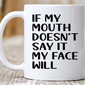 May include: White ceramic coffee mug with a black graphic that reads "If my mouth doesn't say it my face will."