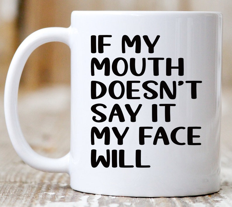 May include: White ceramic coffee mug with a black graphic that reads "If my mouth doesn't say it my face will."