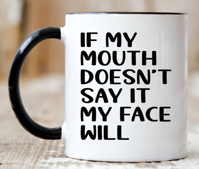 May include: White ceramic coffee mug with a black handle. The mug has black text that reads "If my mouth doesn't say it my face will."