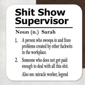 May include: A square white coaster with rounded corners featuring black printed text that reads: Shit Show Supervisor, Noun (n.) Sarah, 1. A person who swoops in and fixes problems created by other fuckwits in the workplace. 2. Someone who does not get paid enough to deal with all this shit. Also see: miracle worker, legend.