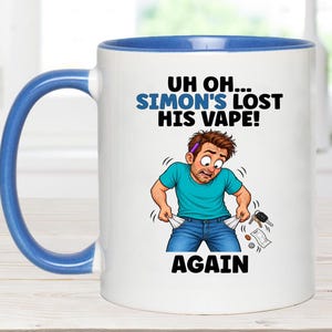 May include: A white ceramic mug with a blue interior and handle, featuring a cartoon illustration of a person with brown hair wearing a teal shirt and blue jeans, looking distressed with empty pockets. Text reads: UH OH... SIMON'S LOST HIS VAPE! AGAIN.