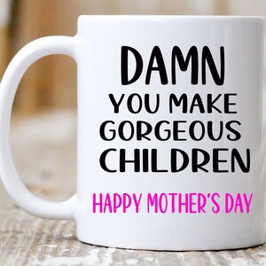 May include: White ceramic coffee mug with black text that reads "DAMN YOU MAKE GORGEOUS CHILDREN HAPPY MOTHER'S DAY" with the word "HAPPY" in pink.