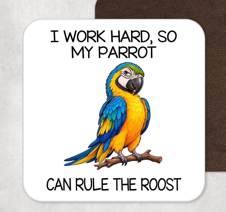 May include: A square white coaster featuring a colorful blue and yellow macaw parrot perched on a brown branch. The text above the bird reads I WORK HARD, SO MY PARROT and the text below the bird reads CAN RULE THE ROOST in black font.