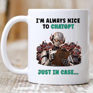 May include: A white ceramic mug featuring a graphic of a central robot holding a clipboard with a logo, surrounded by a group of similar robots with glowing red eyes. The text reads I'M ALWAYS NICE TO CHATGPT JUST IN CASE... in black and teal.