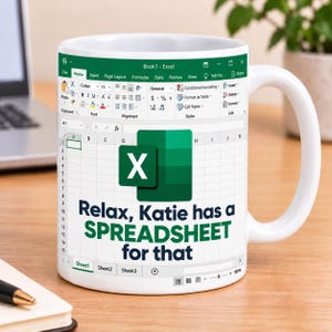 May include: A white ceramic mug featuring a printed Microsoft Excel interface design. The mug displays the green Excel logo and the text "Relax, Katie has a SPREADSHEET for that" in dark blue and green lettering over a grid of spreadsheet cells.
